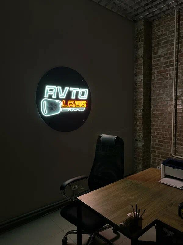 Круглый световой логотип AVTO на стене в зоне ожидания