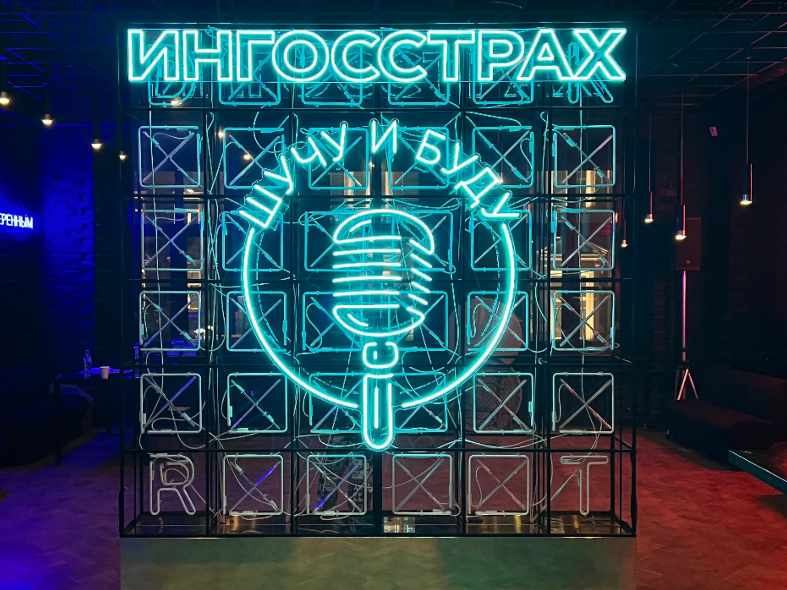 Бирюзовая неоновая надпись на стене кафе, вид помещения с мебелью